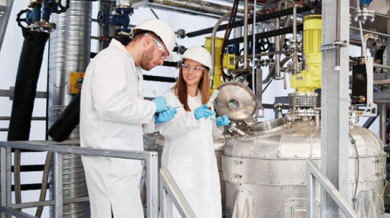 Two scientists in white coats stand in a factory environment at the Fraunhofer Institute for Process Engineering and Packaging IVV in Germany