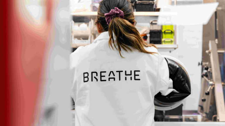 Lab technician with BREATHE written on her back.