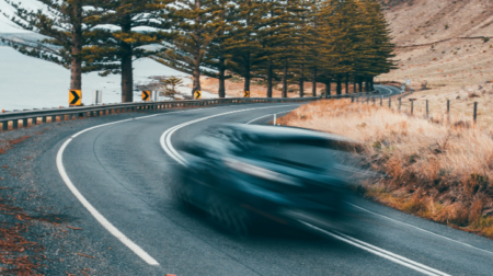 A blurred car driving on a winding road