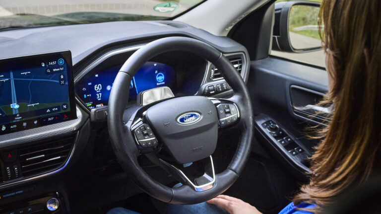 Woman sits in the driving seat with the BlueCruise hands-off, eyes-on technology engaged