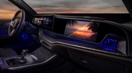 Harman announces industry-first automotive certification for Ready Display technology the dashboard display in a sleek, dark vehicle with the sun setting in the distance outside.
