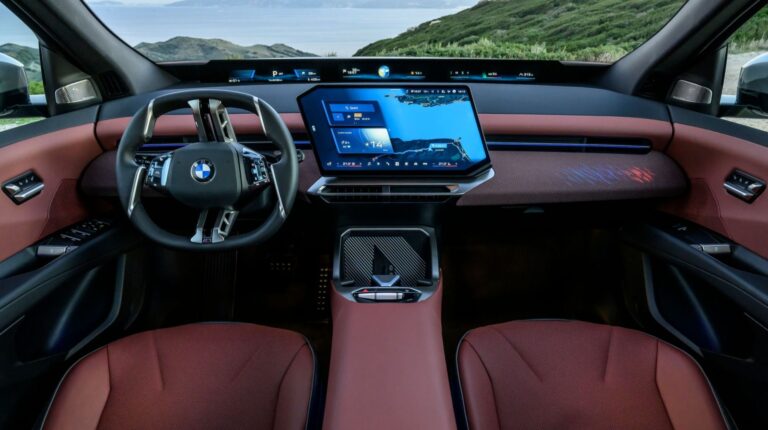 The cockpit of the the BMW iX3, with a central display unit and maroon coloured upholstery