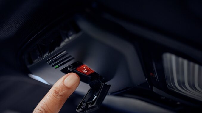 A finger moves toward a red SOS button in a vehicle display.