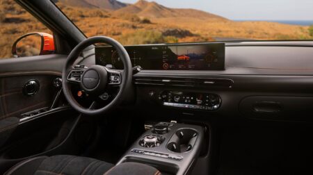 Exclusive drive modes and e-ASD+ deliver an immersive cabin experience in the Genesis GV60 The dash of the Genesis GV60 Magma in light and dark greys with a dry rural environment visible through the windshield.