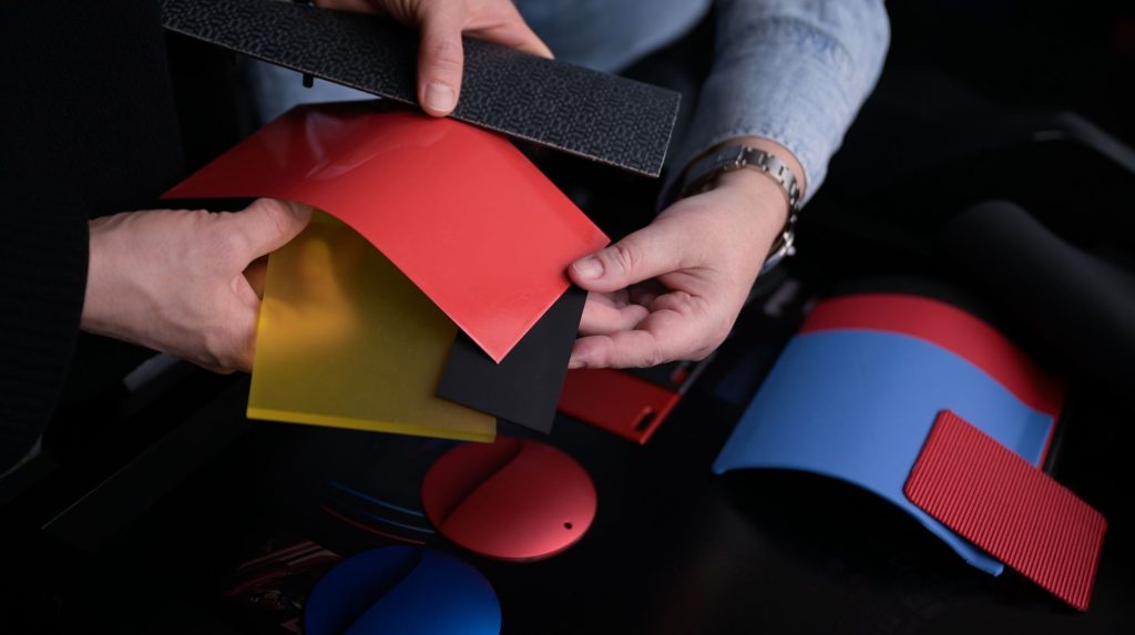 A person looks through a range of Bcomp and BMW M biocomposite material samples in a range of colors
