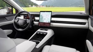 The interior of the Skoda Peaq, with light grey seating, dark blue dash and green grass visible through the windshield.