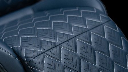 Magna develops sustainable seating material incorporating bio-based and recycled inputs Close up of the sustainable automotive seating material from Magna, in a grey color with a zigzag pattern.