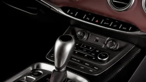 Dashboard and gear stick inside a vehicle in black and brown colors.